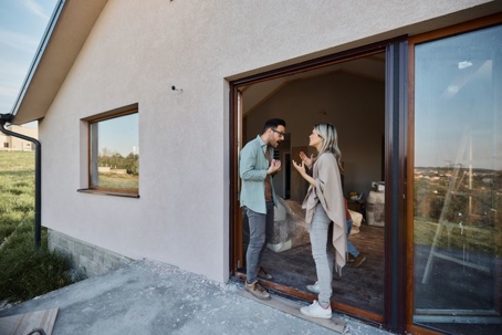 Young couple arguing on the door of their new home.